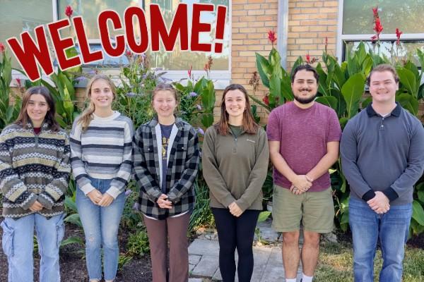 Group photo of new AELers with text "Welcome!" in red above them